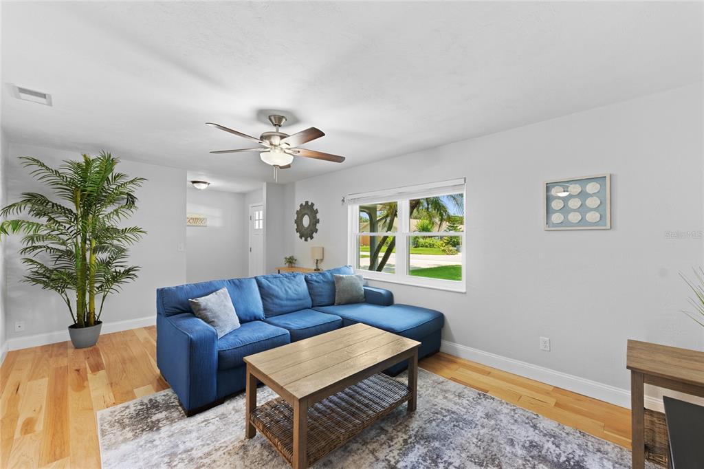 A living room features a blue sectional sofa, a wooden coffee table, and a potted plant — 909 BENTWOOD LANE UNIT 1, PORT ORANGE, FL