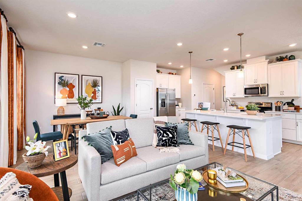 An open-concept living room and kitchen featuring white cabinetry, a kitchen island, and dining area — 1789 TERRAPIN ROAD, OCOEE, FL