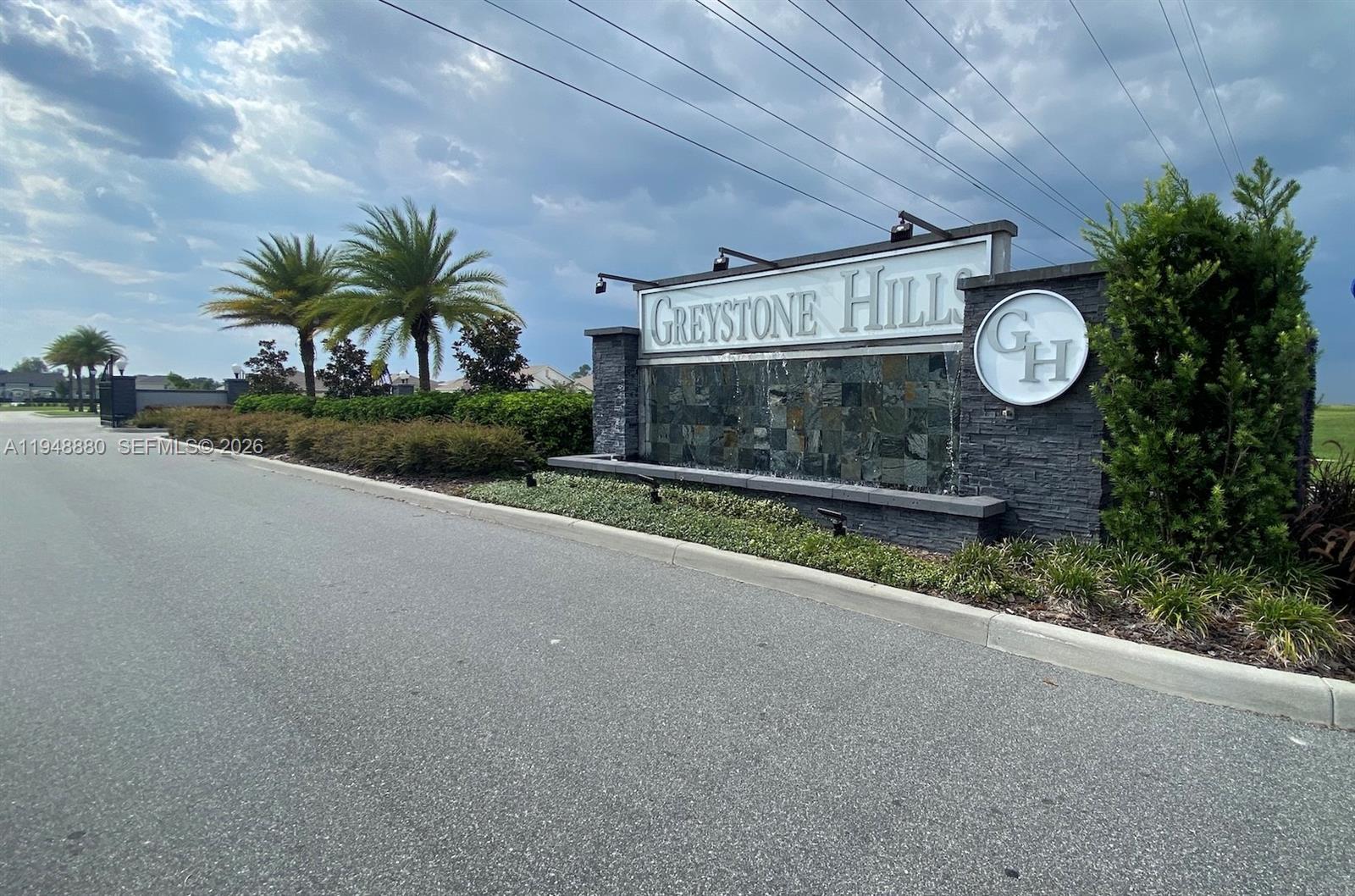 A stone entrance sign for Greystone Hills features a water feature and palm trees — 4961 SW 88 PL, Ocala FL 34476, OCALA, FL