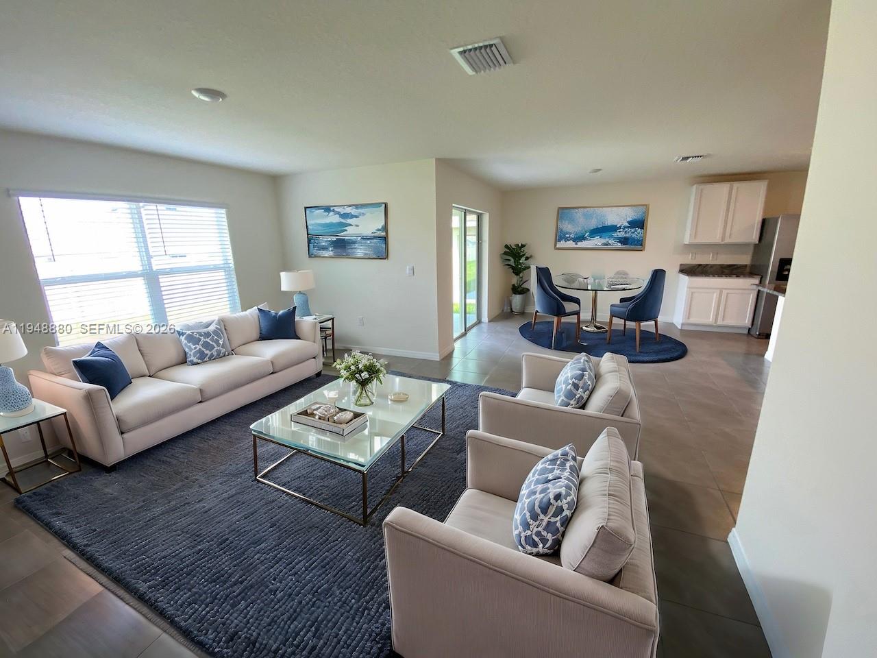 A living room and dining area feature neutral furniture, a glass coffee table, and tile floors — 4961 SW 88 PL, Ocala FL 34476, OCALA, FL