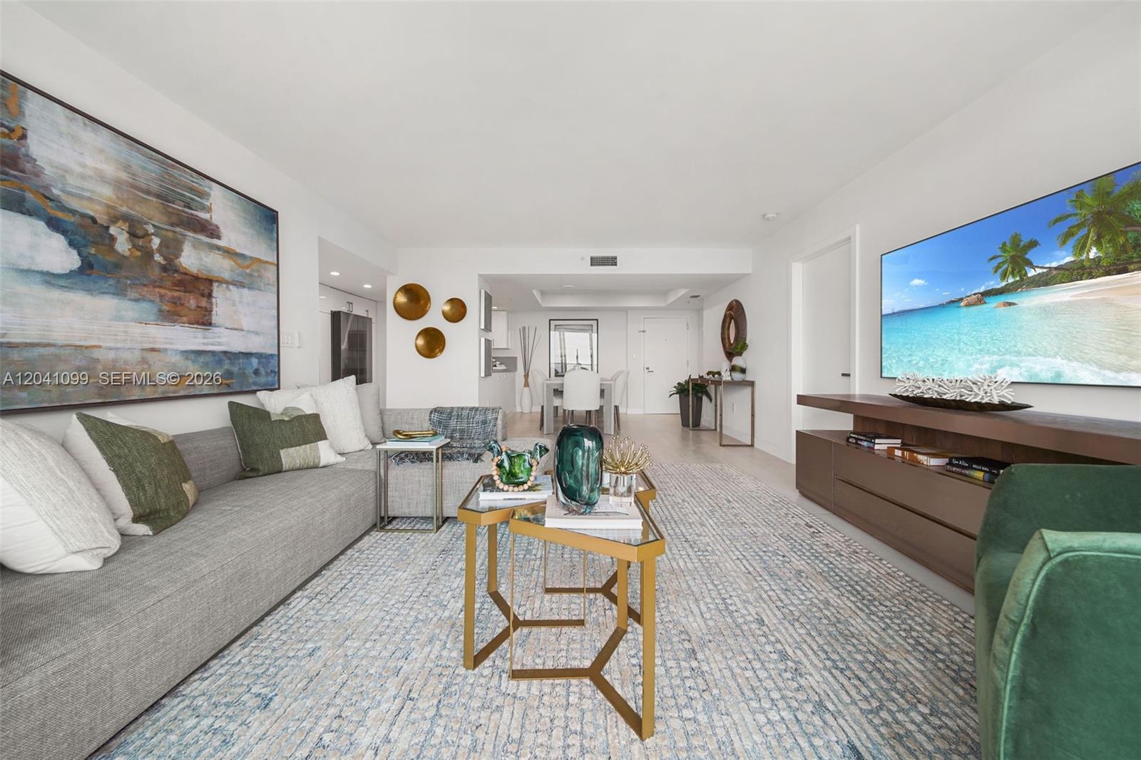 A modern living room features a gray sectional sofa, a glass coffee table, and a television — 650 West Ave # 1908, Miami Beach FL 33139, MIAMI BEACH, FL