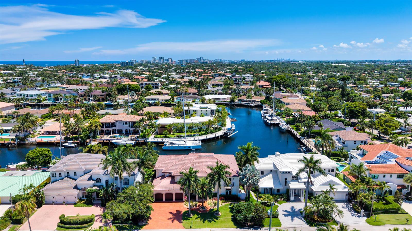 An aerial view shows waterfront homes with swimming pools, docks, and boats along a canal — 2320 NE 34th Court, Lighthouse Point FL 33064, LIGHTHOUSE POINT, FL
