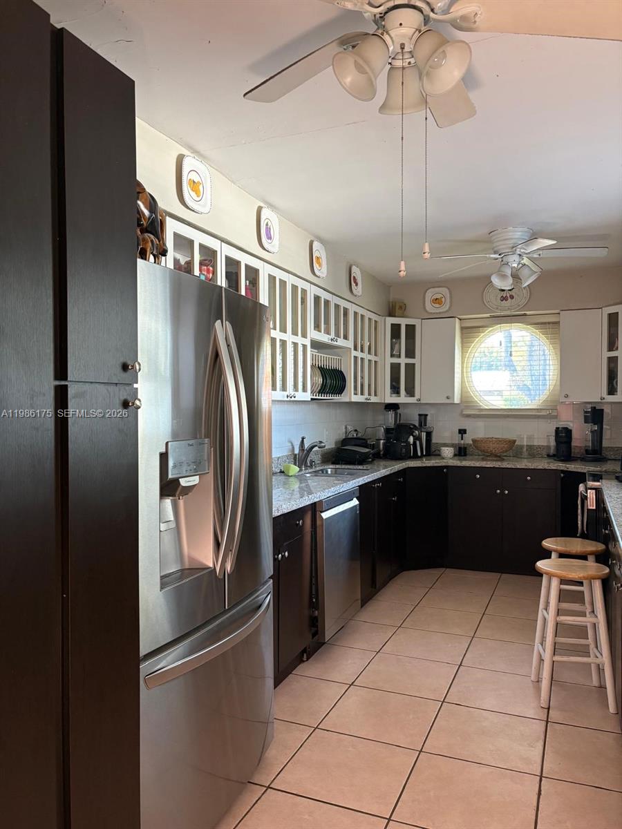 A kitchen features dark cabinets, stainless steel appliances, granite countertops, and two wooden bar stools — 1758 SW 18th St, Miami FL 33145, MIAMI, FL