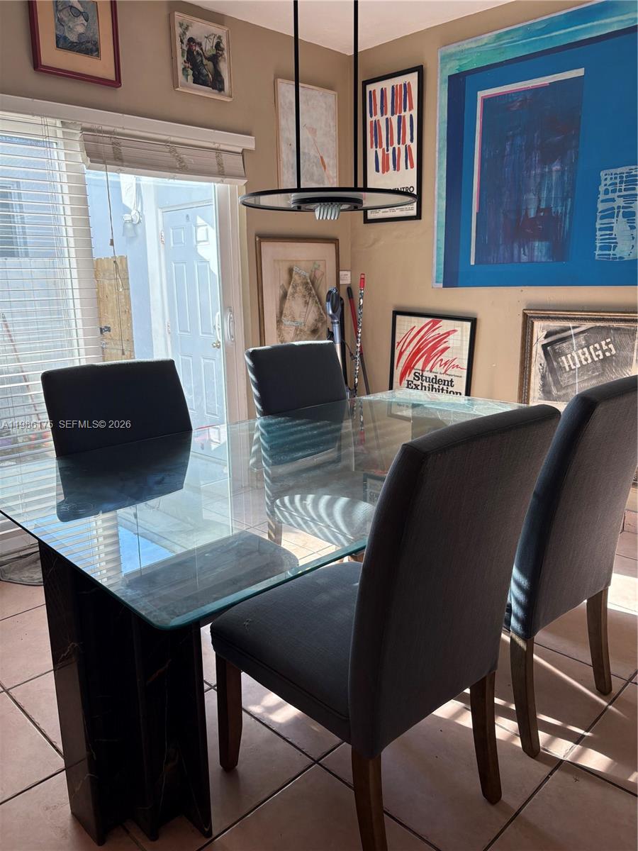 A dining room features a glass-topped table, dark upholstered chairs, and several framed art pieces — 1758 SW 18th St, Miami FL 33145, MIAMI, FL