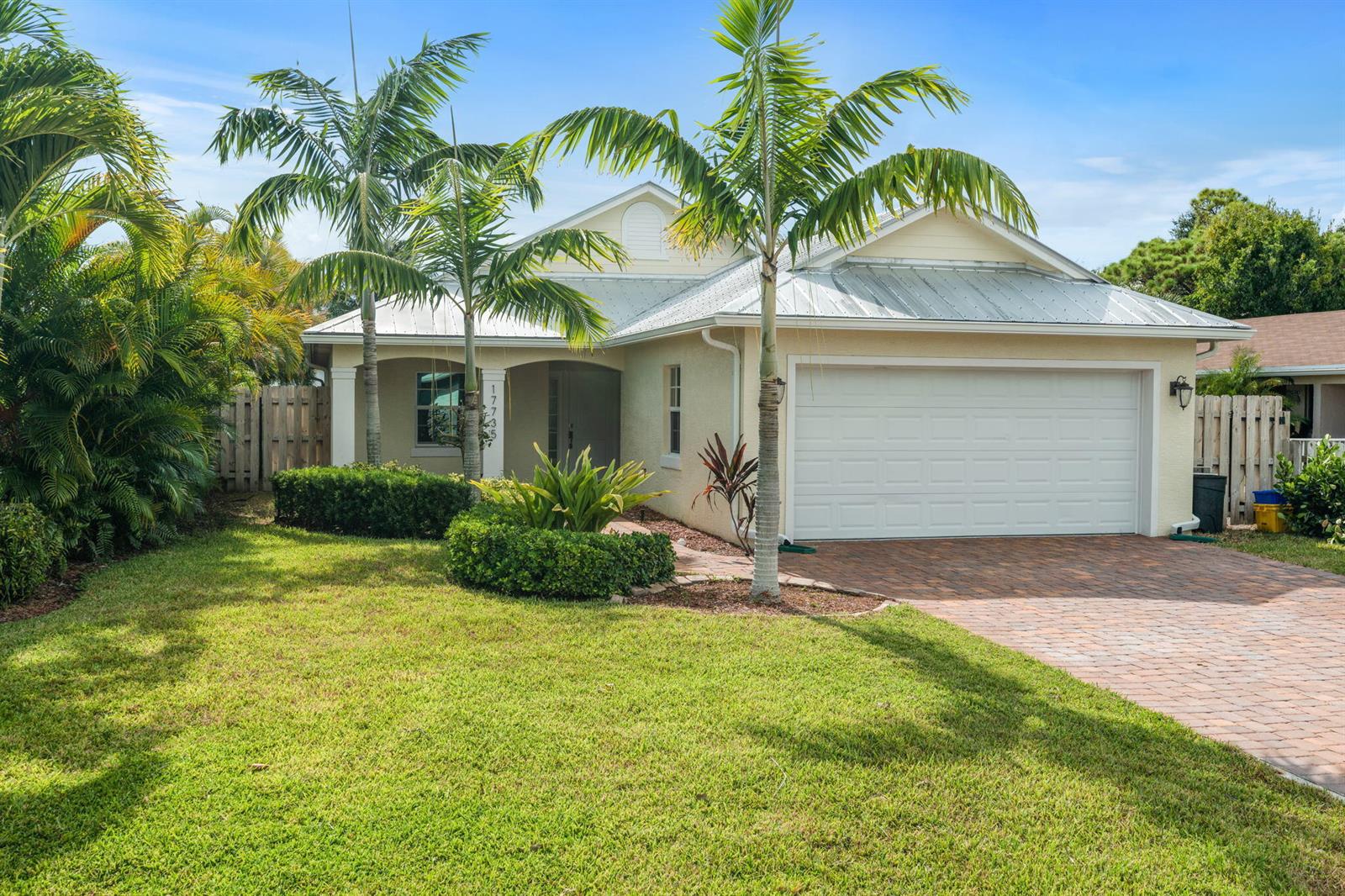 A single-story house with a metal roof, palm trees, and a brick paver driveway — 17735 CARVER Avenue, Jupiter FL 33458, JUPITER, FL