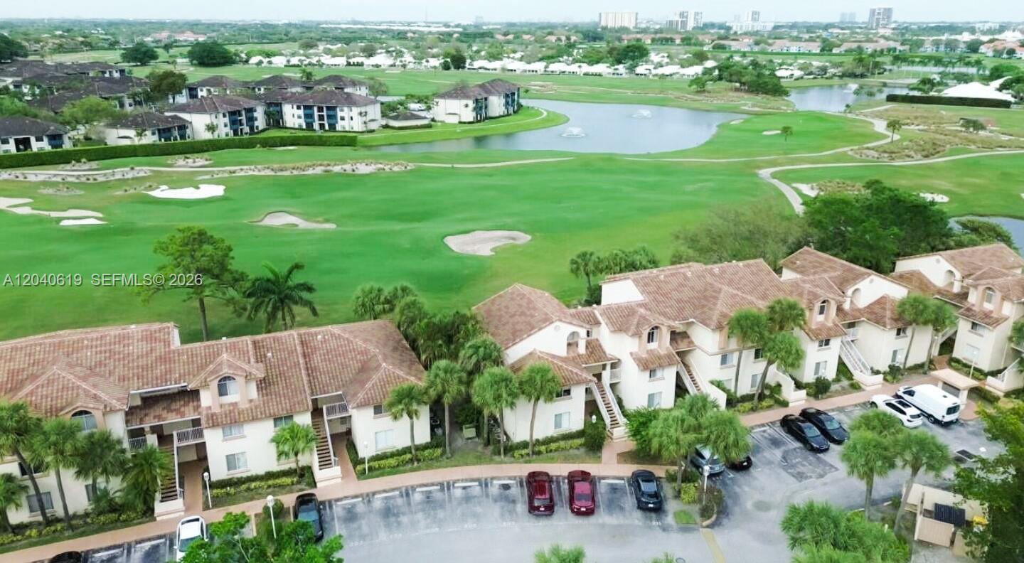 An aerial view shows a multi-story residential complex overlooking a golf course and lake — 3204 Glenmoor Dr # 3204, West Palm Beach FL 33409, WEST PALM BEACH, FL