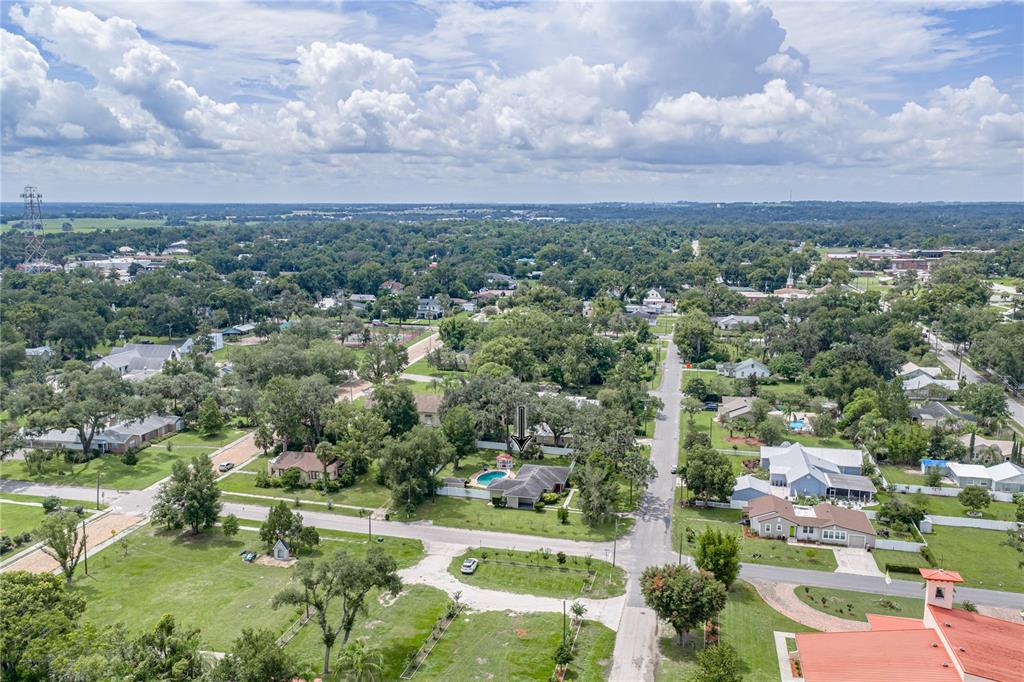 An aerial view shows a residential neighborhood with a house featuring a backyard swimming pool — 14320 13TH STREET, DADE CITY, FL