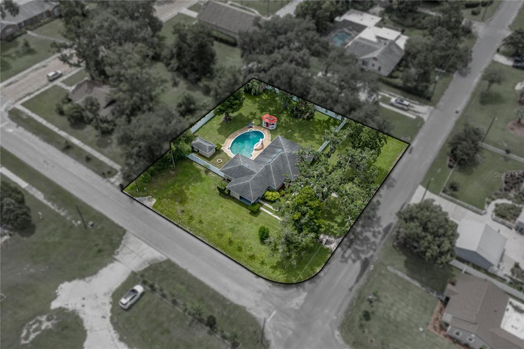 An aerial view shows a house with a swimming pool and gazebo on a corner lot — 14320 13TH STREET, DADE CITY, FL