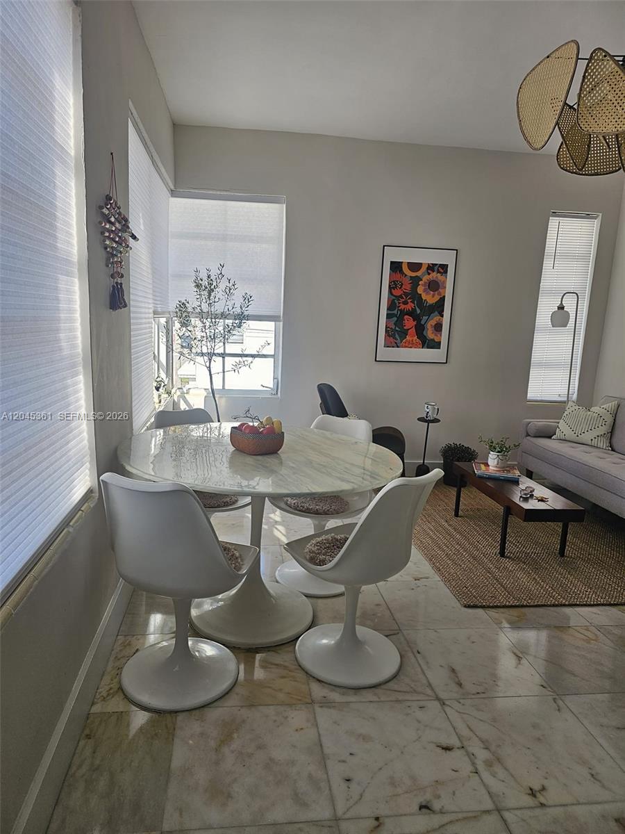 A dining area with a marble tulip table and white chairs sits beside a living space — 801 8th St # 201, Miami Beach FL 33139, MIAMI BEACH, FL
