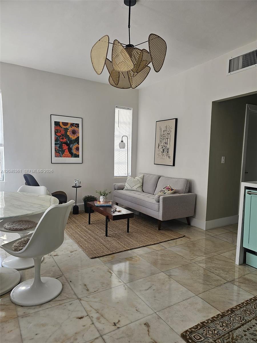 A living room features a grey sofa, a rattan chandelier, and light-colored tile flooring — 801 8th St # 201, Miami Beach FL 33139, MIAMI BEACH, FL