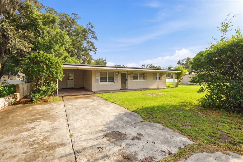 A single-story house with a concrete driveway, a carport, and a grassy front yard — 452 OAKHURST STREET, ALTAMONTE SPRINGS, FL