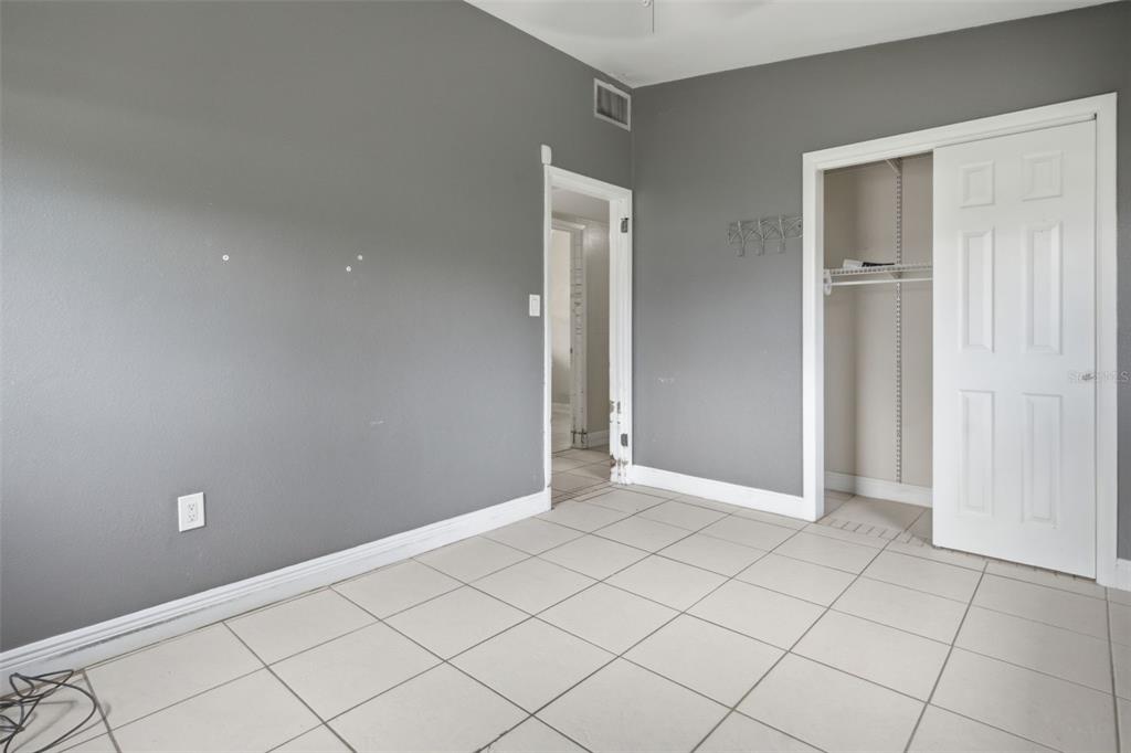 A room with gray walls, white trim, tiled flooring, a doorway, and a closet — 452 OAKHURST STREET, ALTAMONTE SPRINGS, FL