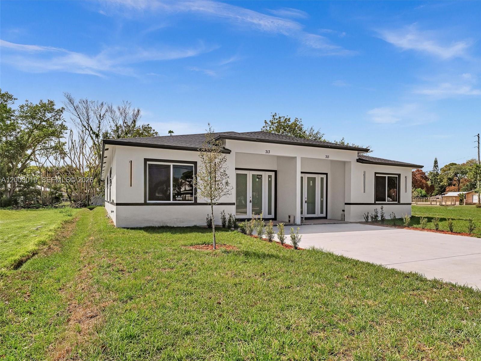 A modern, white single-story duplex with a flat roof and a concrete driveway — 313 S 13th St, Fort Pierce FL 34950, FORT PIERCE, FL