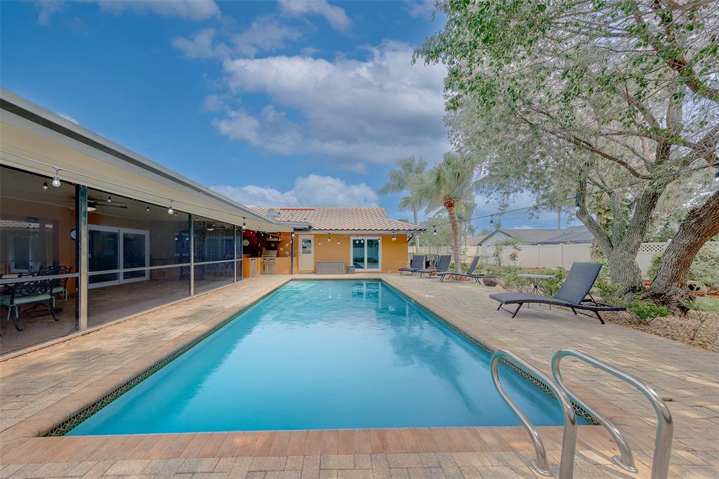 A rectangular swimming pool sits on a paved patio beside a house with a screened porch — 4119 CROSSWATER DRIVE, TAMPA, FL
