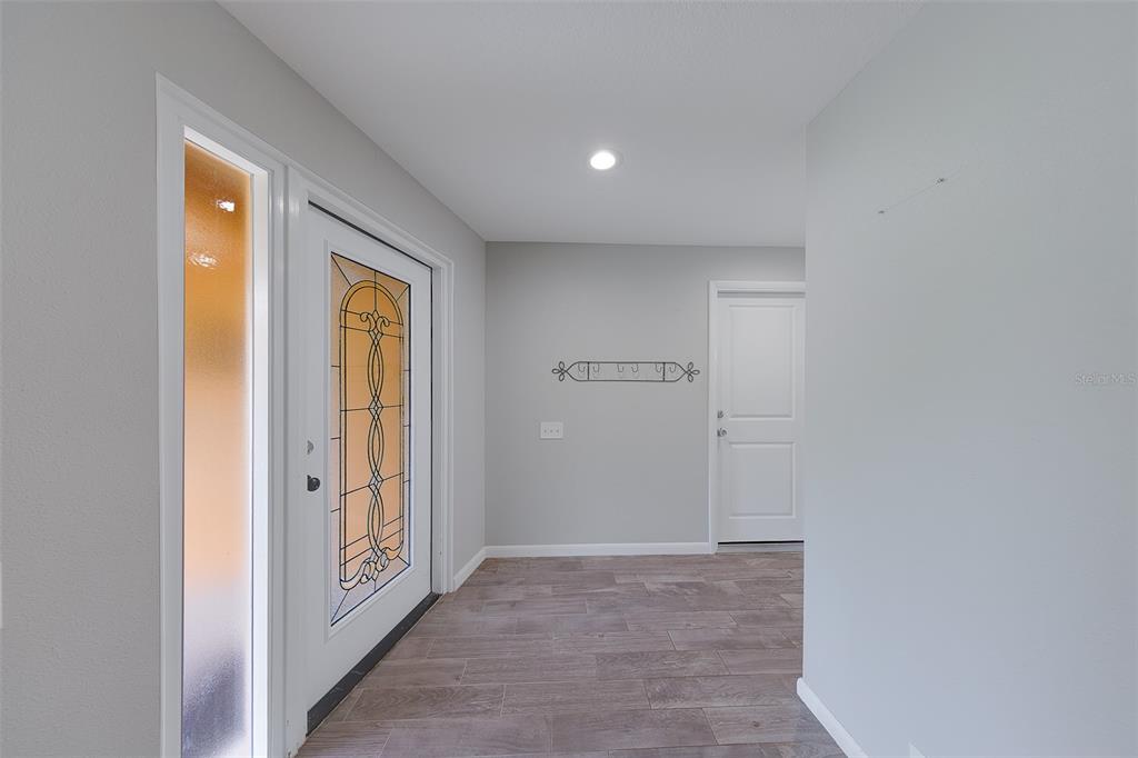 An entryway with a decorative glass front door, light gray walls, and wood-look tile flooring — 4119 CROSSWATER DRIVE, TAMPA, FL