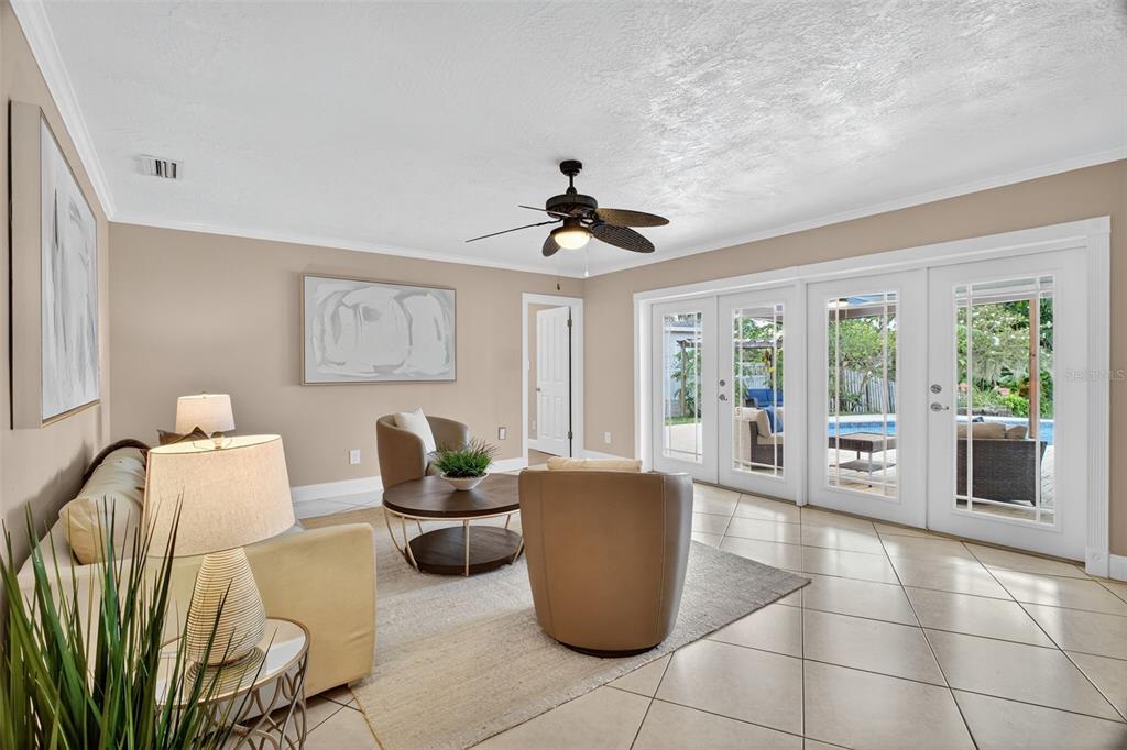 A living room with beige walls, tile floors, a ceiling fan, and glass patio doors — 2514 TUSCARORA TRAIL, MAITLAND, FL