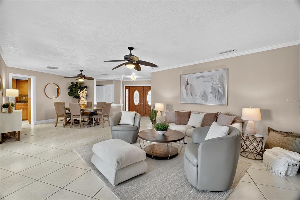 An open-concept living and dining area features tile flooring, neutral walls, and two ceiling fans — 2514 TUSCARORA TRAIL, MAITLAND, FL