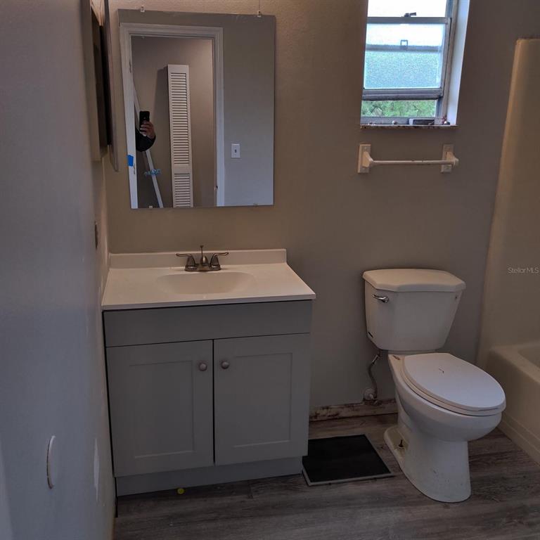 A bathroom features a gray vanity, a white sink, a mirror, and a toilet — 722 W COLUMBIA AVENUE UNIT 722, KISSIMMEE, FL