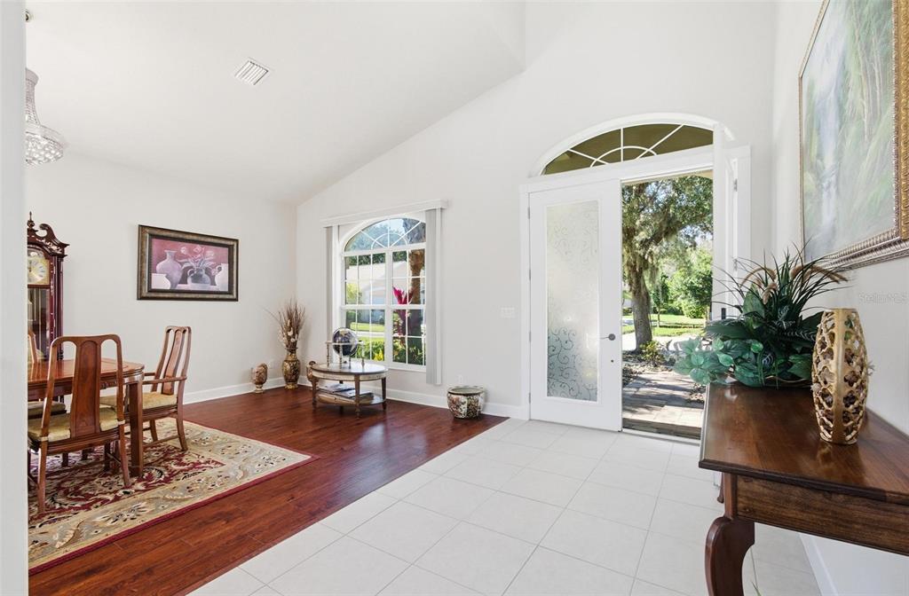 A dining area with wood floors and a tiled entryway featuring an open front door — 17 SANDPIPER COURT, PALM COAST, FL