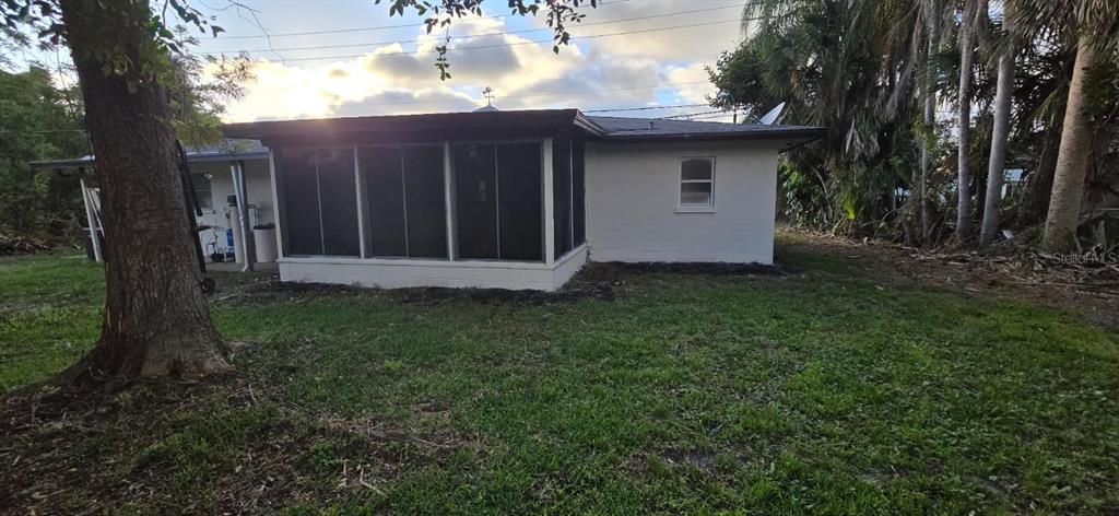 A white house exterior features a screened-in porch and a small window on the side — 345 S VENICE BOULEVARD, VENICE, FL