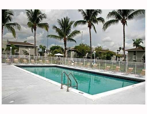 An outdoor rectangular swimming pool is surrounded by a white fence and palm trees — 426 NE 210th Cir Ter # 2, Miami FL 33179, MIAMI, FL