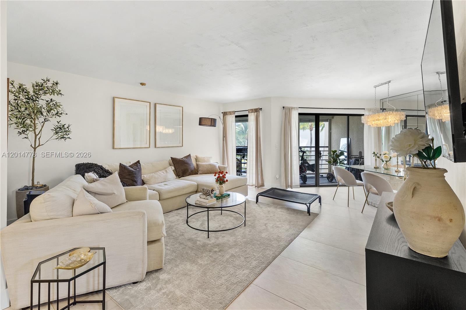 A living room features a large sectional sofa, a glass coffee table, and a dining area — 5850 Camino Del Sol # 404, Boca Raton FL 33433, BOCA RATON, FL