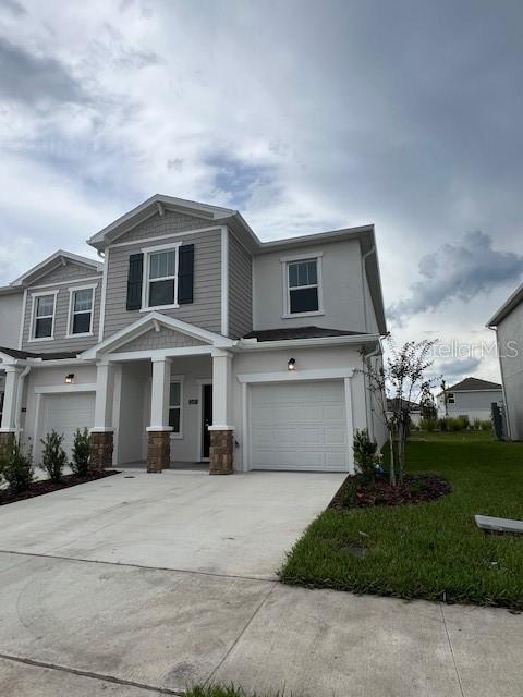 A two-story suburban home features a gray exterior, a single-car garage, and a concrete driveway — 2691 SKYLINE LOOP, KISSIMMEE, FL