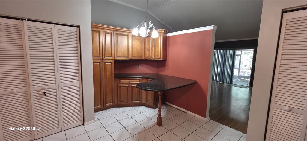 A kitchen area features wood cabinets, a dark countertop, and a white tiled floor — 3205 LAUREL DALE DRIVE, TAMPA, FL