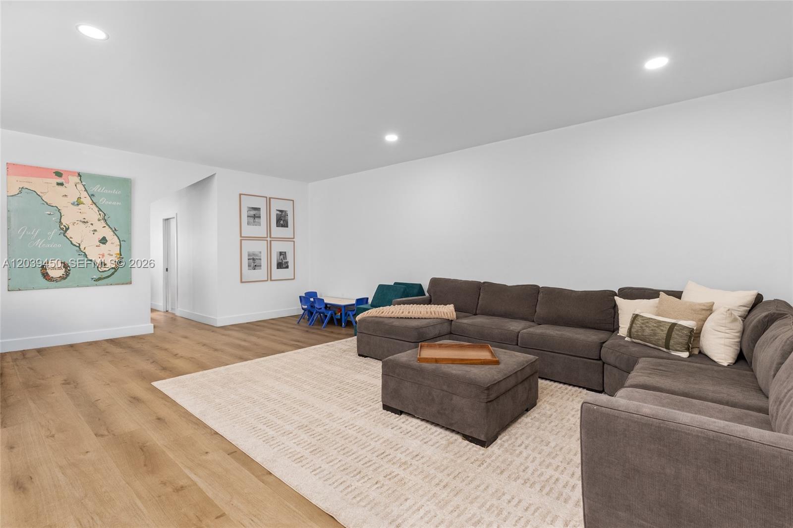 A living room features a large gray sectional sofa, a rug, and a Florida map — 3125 Jackson Ave # 3125, Miami FL 33133, MIAMI, FL