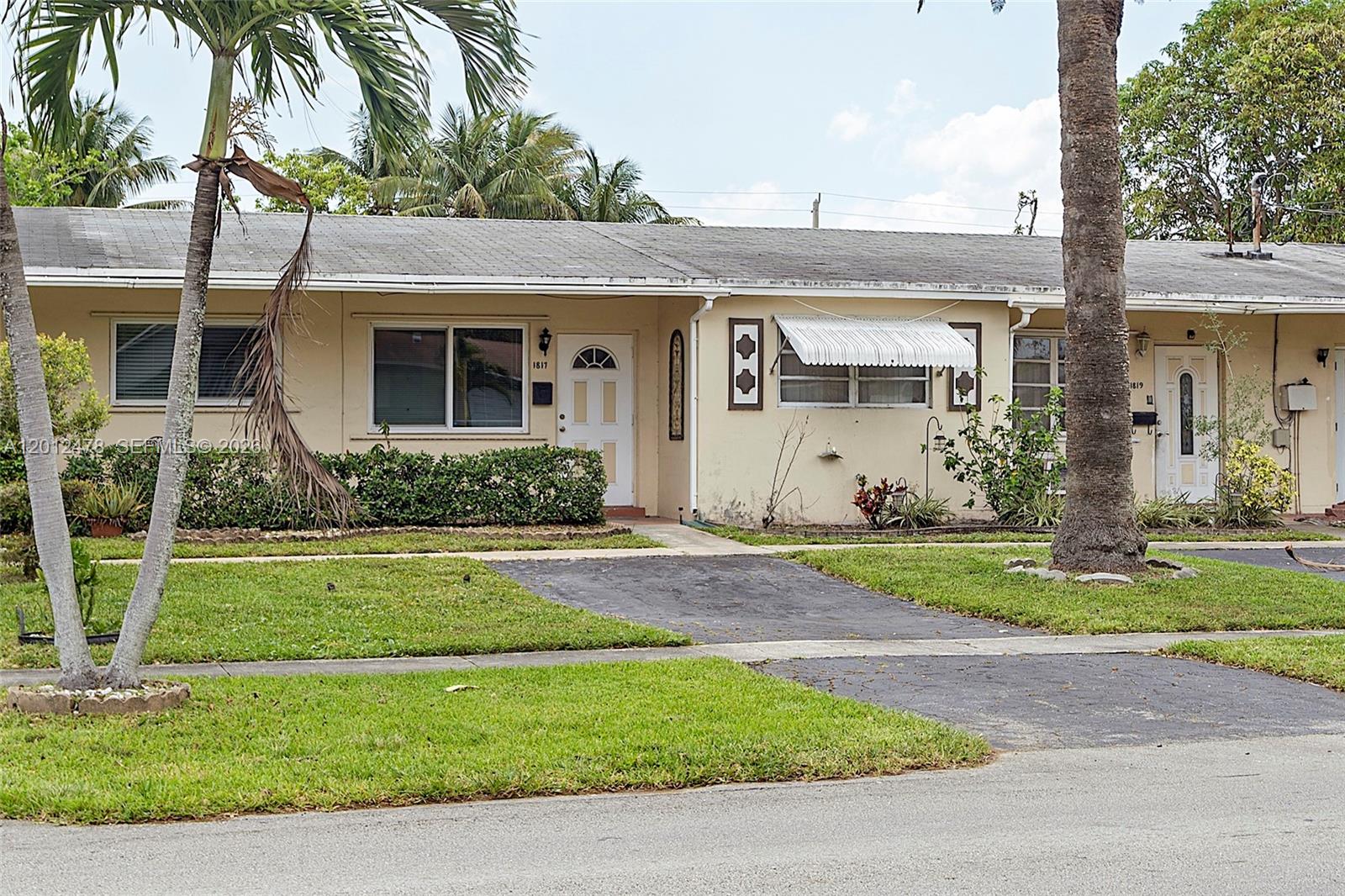 A single-story duplex with beige stucco walls, two front doors, and a palm tree — 1817 NW 60th Ave # G, Sunrise FL 33313, SUNRISE, FL