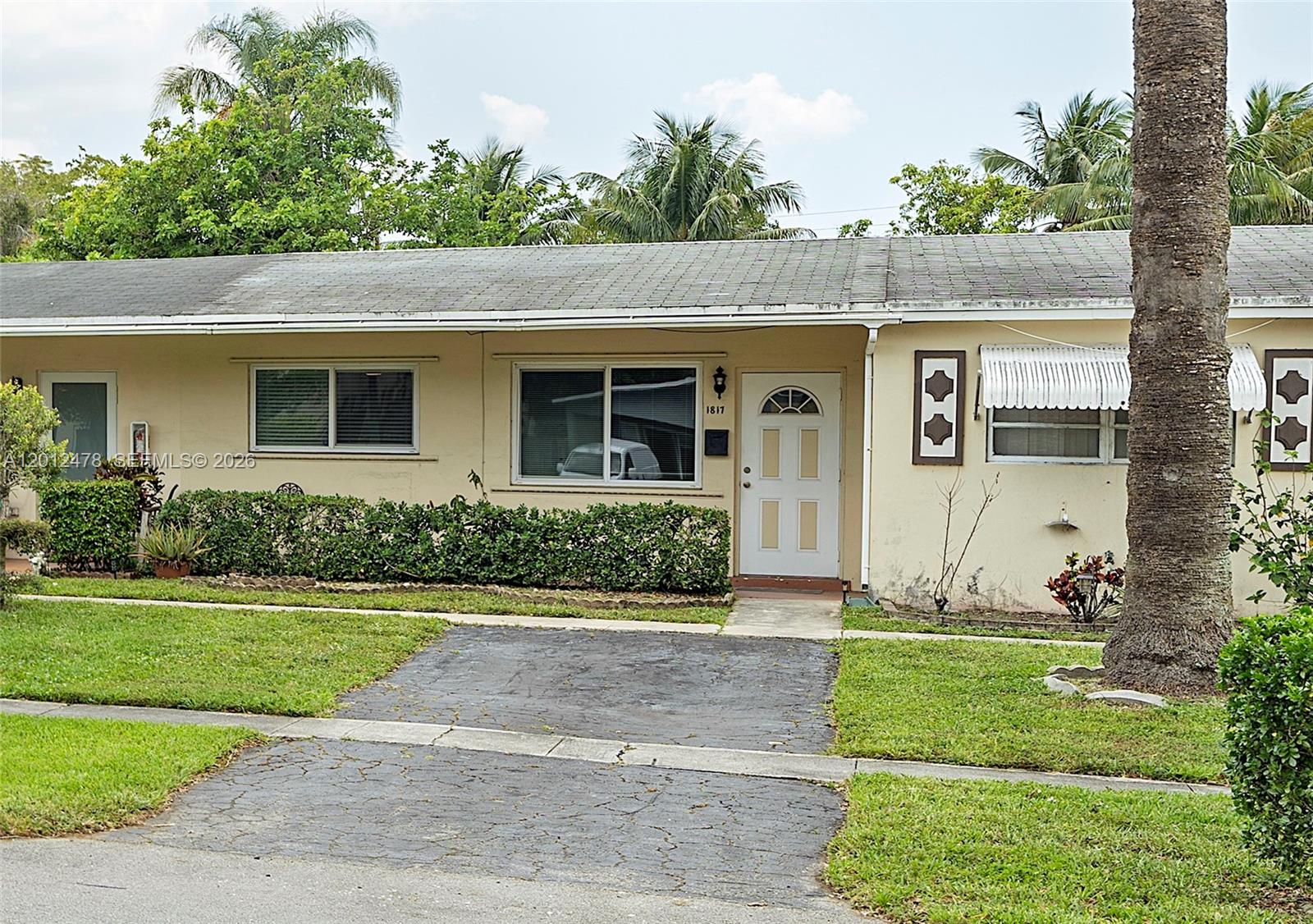 A single-story house with a beige exterior, a small driveway, and a palm tree — 1817 NW 60th Ave # G, Sunrise FL 33313, SUNRISE, FL