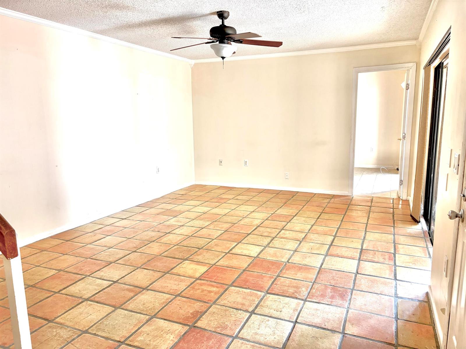 An empty room with terracotta tile flooring, a ceiling fan, and a doorway to another room — 511 5th Terrace, Palm Beach Gardens FL 33418, PALM BEACH GARDENS, FL