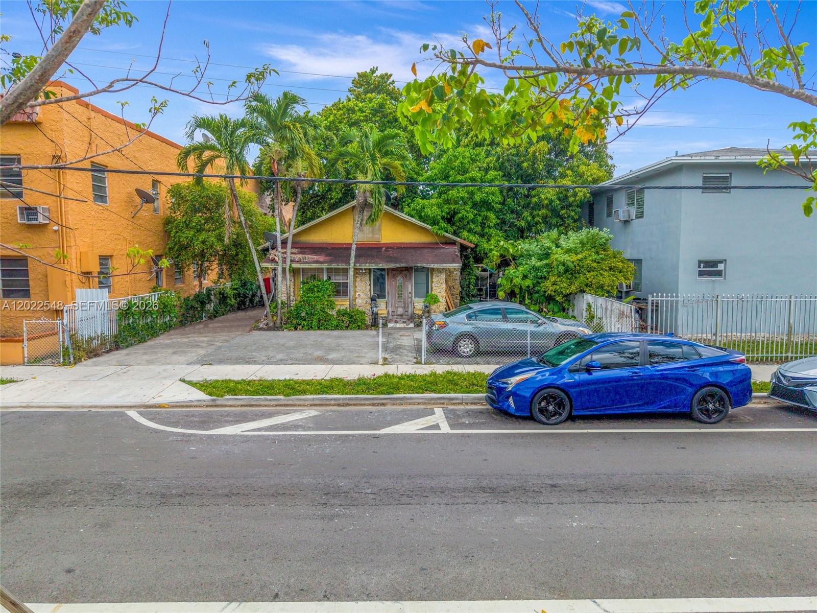 A yellow house with a stone facade sits between two multi-story buildings — 1568 SW 5th St, Miami FL 33135, MIAMI, FL