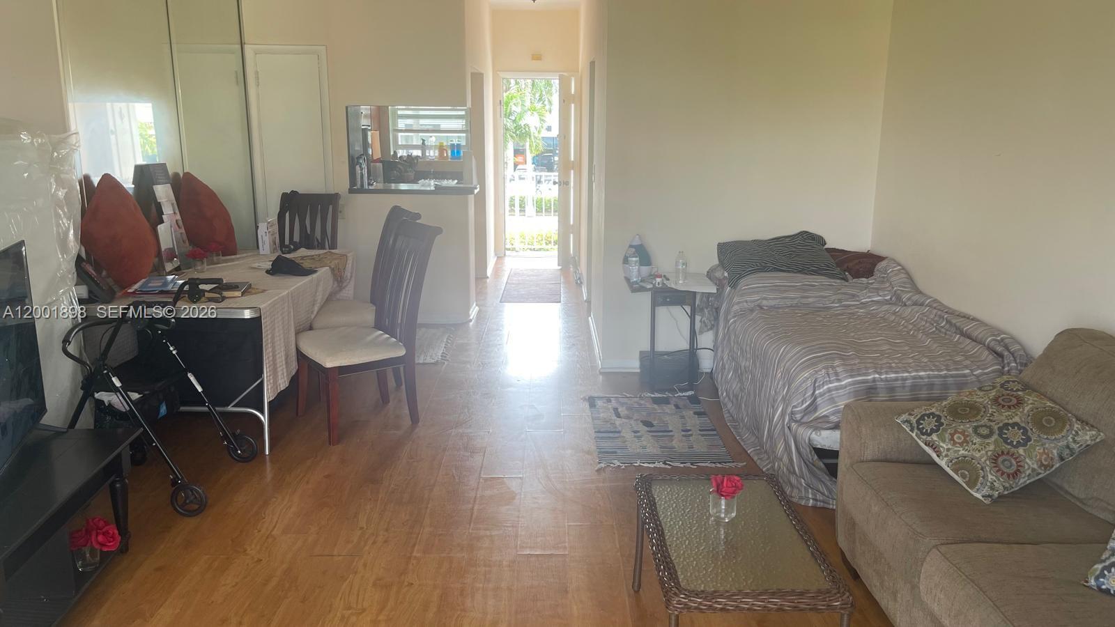 This open-concept living area features a dining space, a bed, and a sofa on tile floors — 2225 NE 123rd St # 204, North Miami FL 33181, NORTH MIAMI, FL