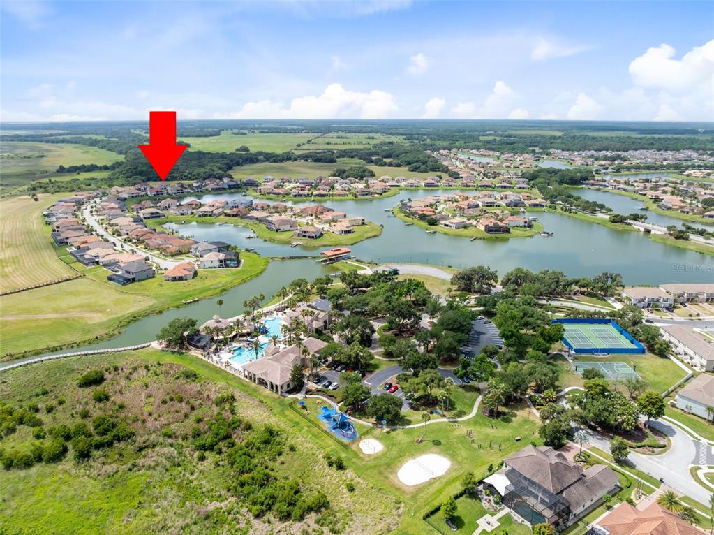 Aerial view of a residential community featuring a large lake, swimming pool, and tennis courts — 900 WINDLASS COURT, KISSIMMEE, FL