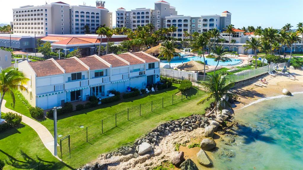 An aerial view shows a multi-unit residential building with a lawn next to a beach — Dorado del Mar Blvd OCEAN VILLAS UNIT 39, DORADO, PR