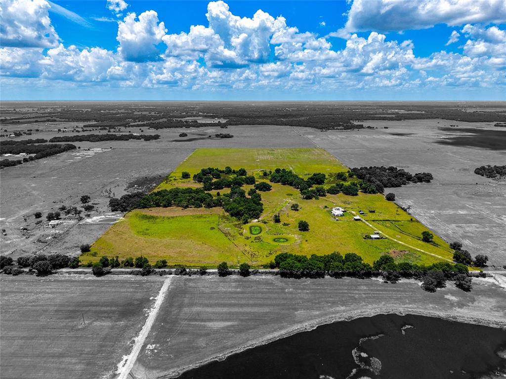 An aerial view shows a large, green rectangular parcel of land surrounded by gray fields — 3030 N NURSERY ROAD, ZOLFO SPRINGS, FL