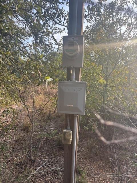 An electrical meter and service panel are mounted on a wooden utility pole outdoors — 20745 NW 302nd Street, Okeechobee FL 34972, OKEECHOBEE, FL