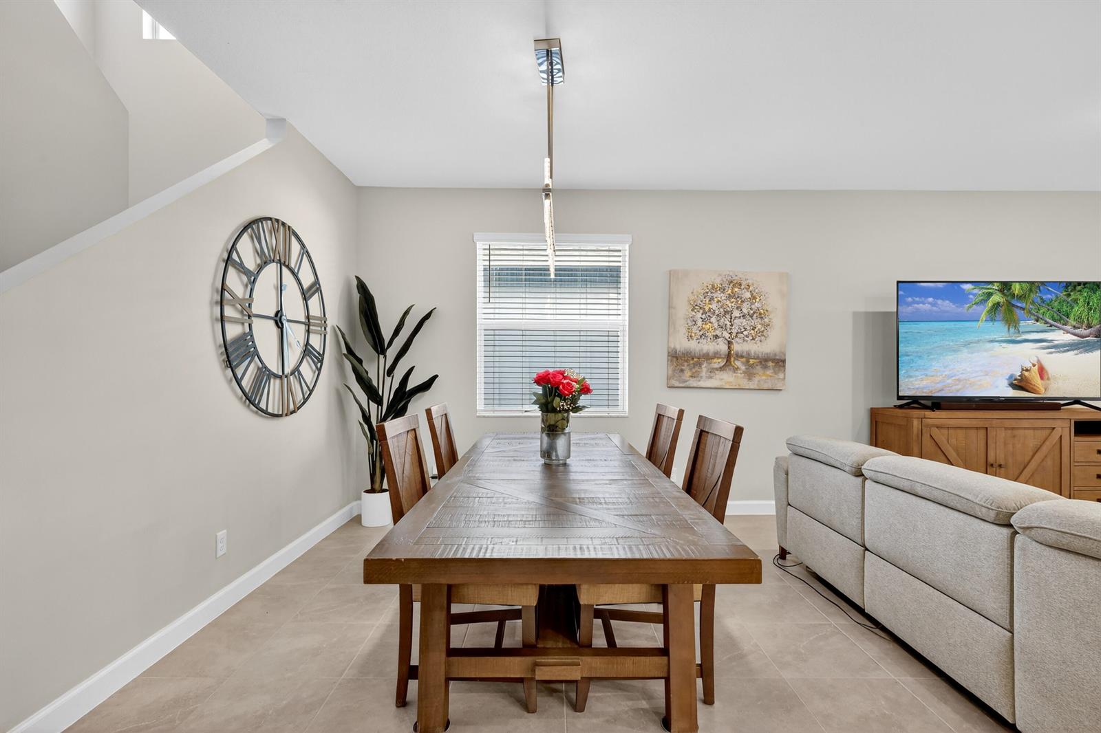 A dining room features a wooden table, six chairs, a large wall clock, and tile flooring — 19753 Tree Stand Terrace, Loxahatchee FL 33470, LOXAHATCHEE, FL