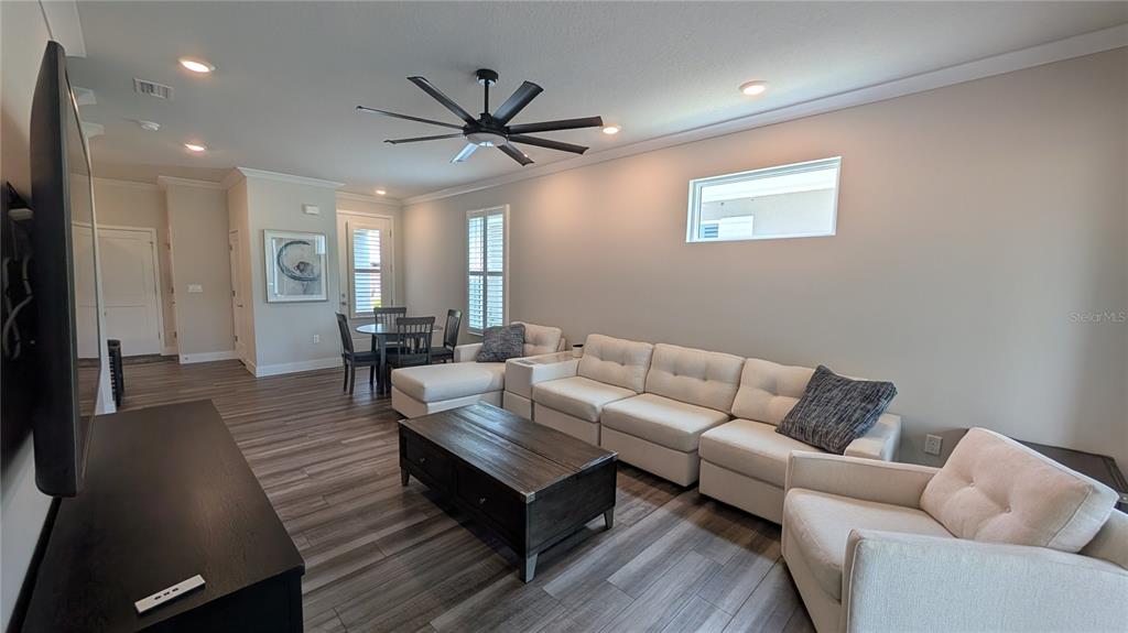 A living room features a white sectional sofa, a dark coffee table, and wood-look flooring — 3062 ISLES WAY, NEW SMYRNA BEACH, FL