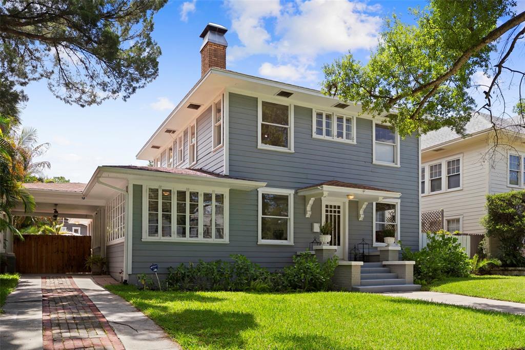 A two-story blue house with a brick driveway, front porch, and chimney under a sky — 703 S EDISON AVENUE, TAMPA, FL