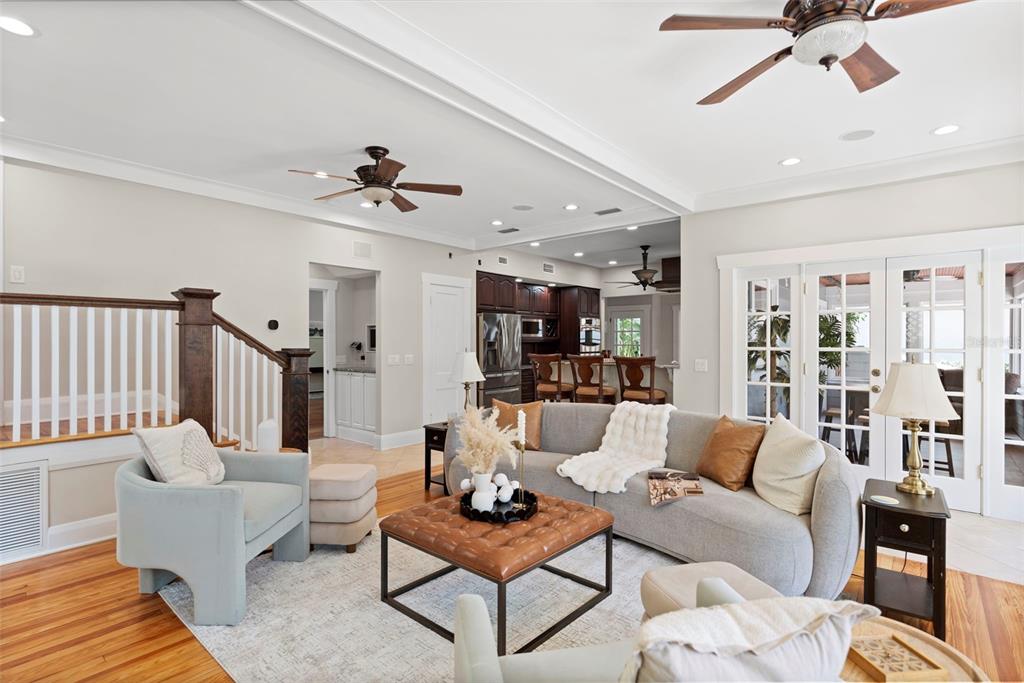 A living room features a gray curved sofa, leather ottoman, and hardwood floors — 703 S EDISON AVENUE, TAMPA, FL