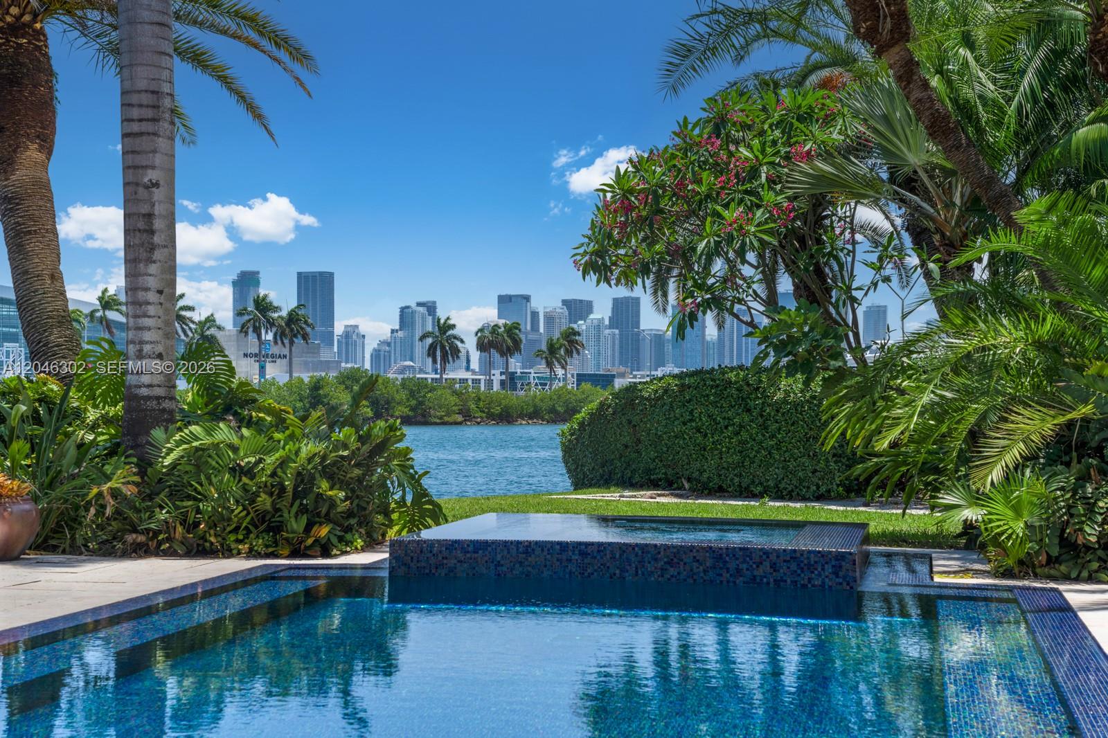 A swimming pool and hot tub overlook a bay with a city skyline in the background — 16 Palm Ave, Miami Beach FL 33139, MIAMI BEACH, FL