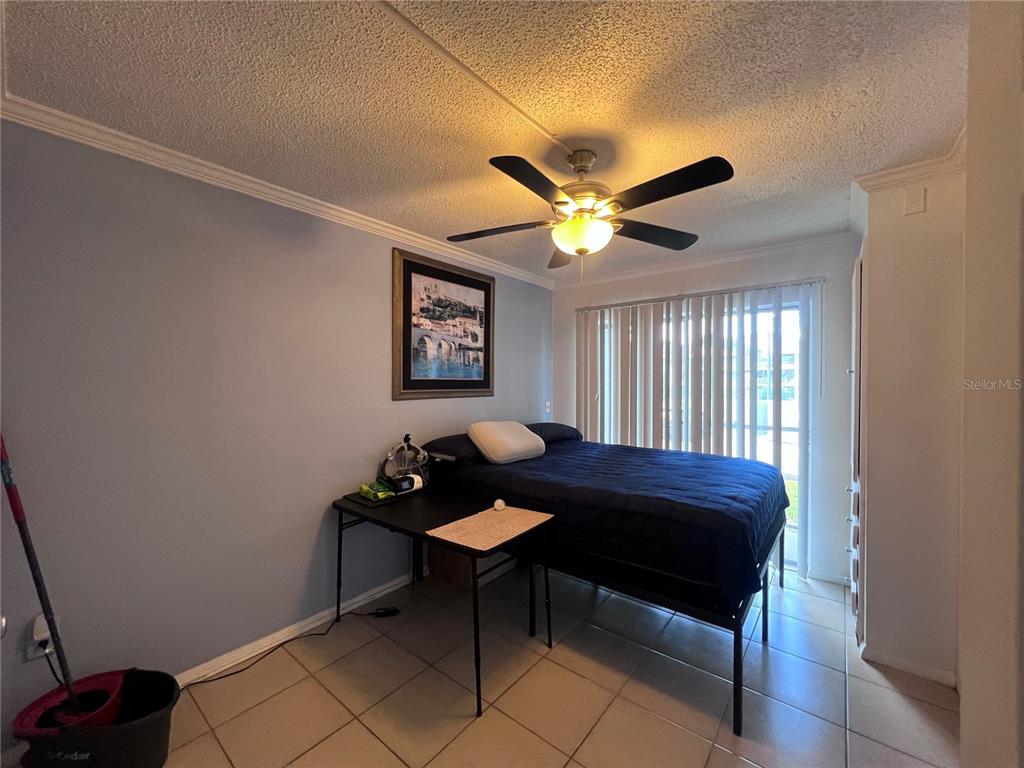 A bedroom features a bed, a desk, tile flooring, and a ceiling fan — 126 BLUE POINT WAY UNIT 100, ALTAMONTE SPRINGS, FL