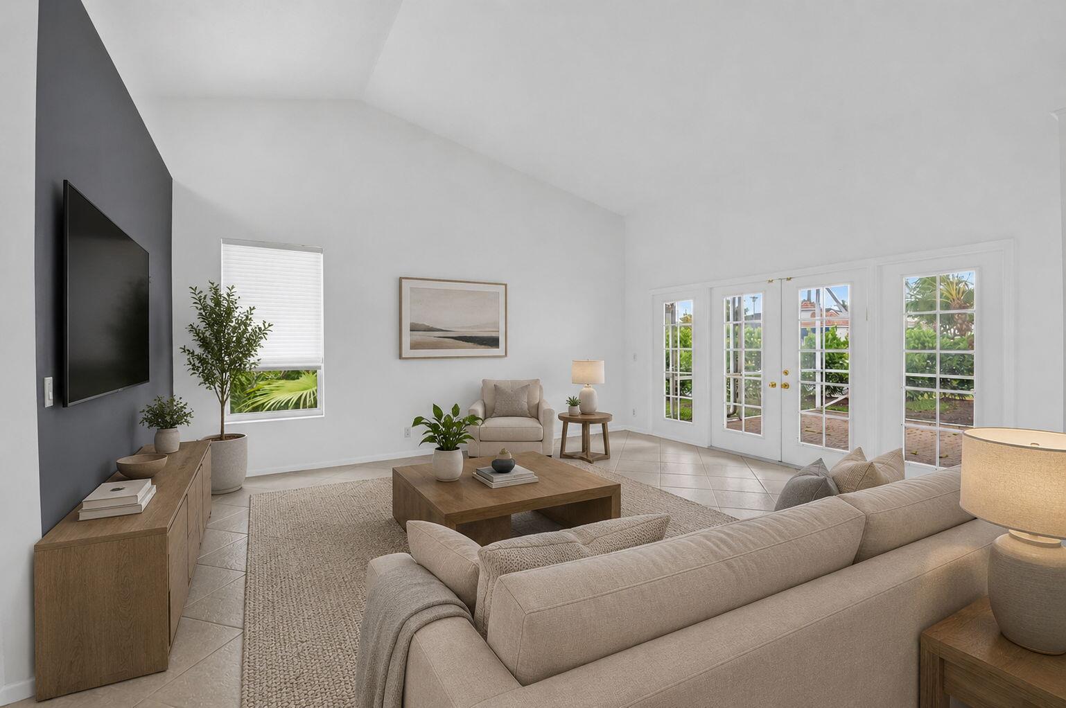 A living room with a vaulted ceiling, beige sofa, wooden coffee table, and glass doors — 23256 Alora Drive, Boca Raton FL 33433, BOCA RATON, FL