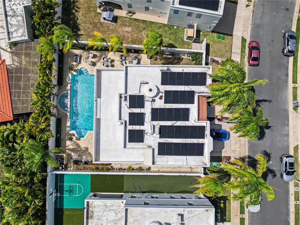 An aerial view shows a house with a swimming pool, solar panels, and a basketball court — B11 CALLE MAR CARIBE, DORADO, PR
