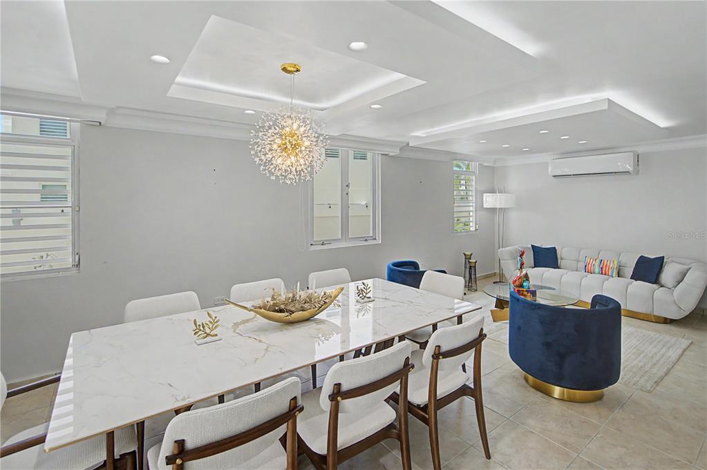 A dining and living area features a marble table, modern chandelier, and white sofa — B11 CALLE MAR CARIBE, DORADO, PR