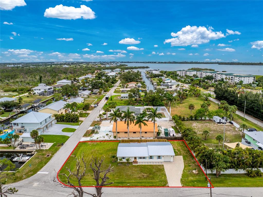An aerial view shows a single-story house with a metal roof on a grassy lot — 8153 ROBERT STREET, ENGLEWOOD, FL