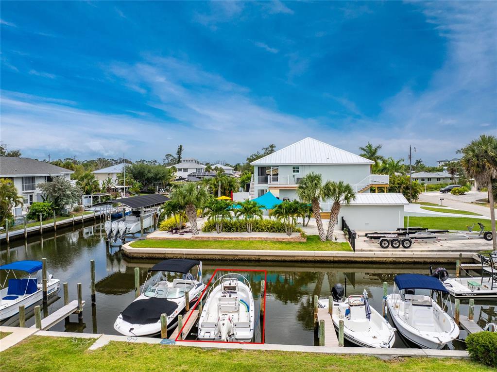 A canal-front property features a house with a boat dock and several moored boats — 8153 ROBERT STREET, ENGLEWOOD, FL