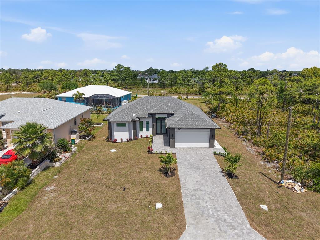 An aerial view of a single-story house with a gray roof and a paved driveway — 90 BRIG CIRCLE S, PLACIDA, FL
